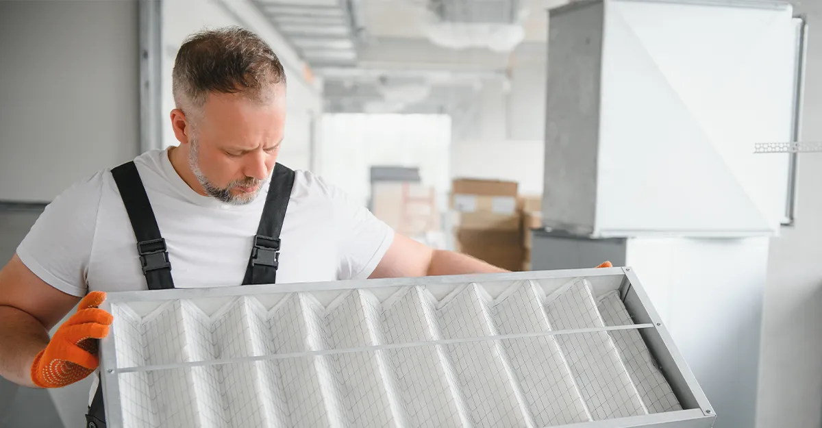 A heating tecchnician holds an expensive furnace filter